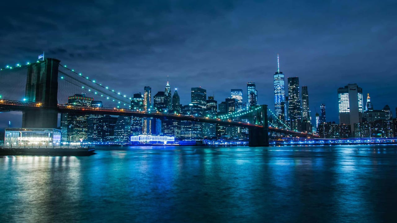 Lower Manhattan and the Brooklyn Bridge at night, seen across the East River